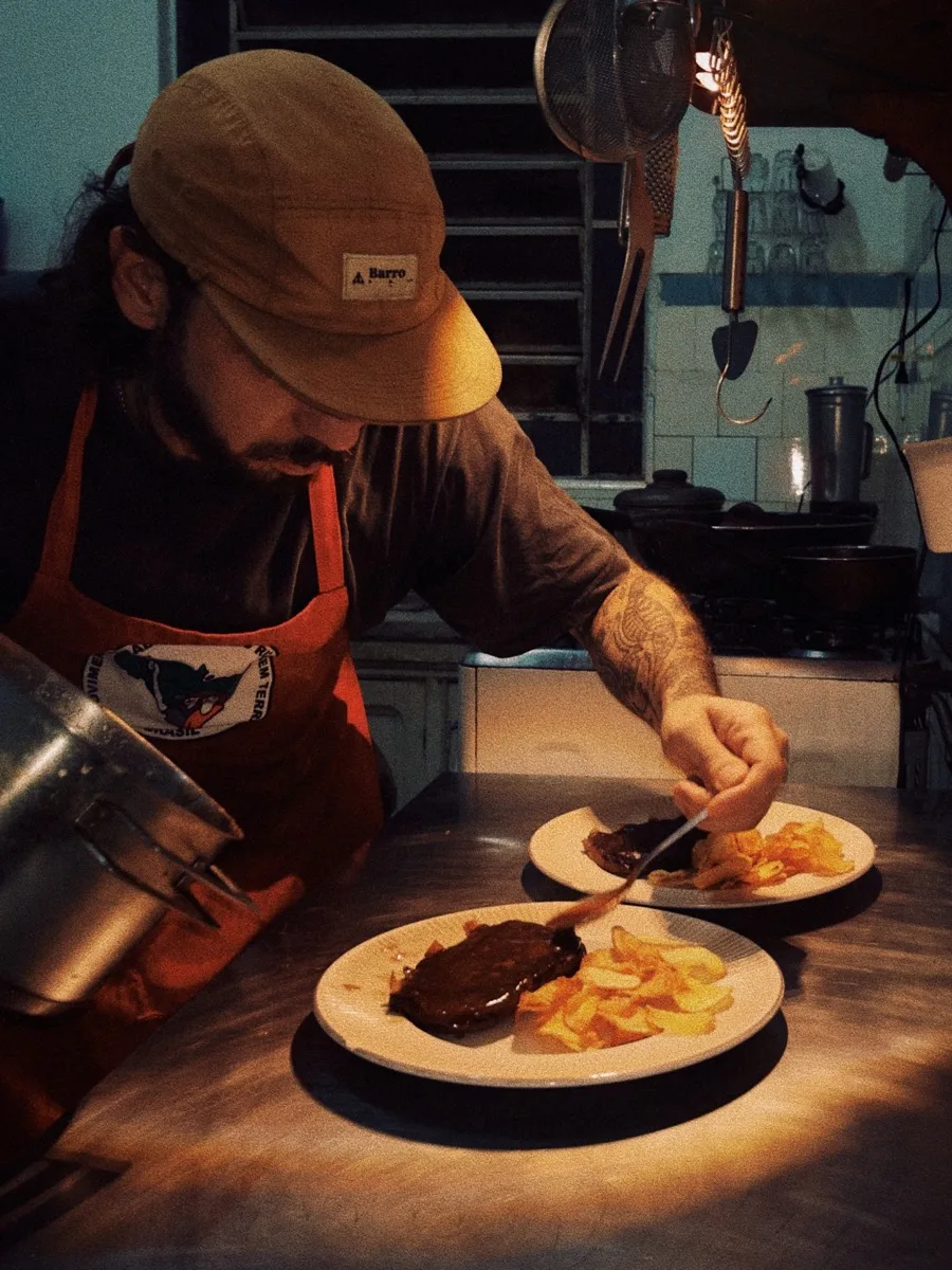 Djalma, chef e dono do Pátio di Dentro, servindo um prato na cozinha