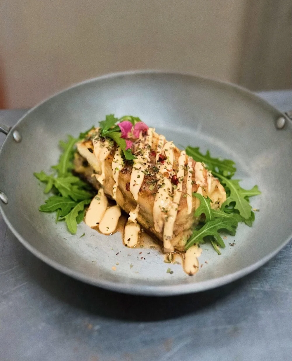 Escondidinho de brócolis com requeijão de castanhas, finalizado com rúcula em prato fundo de pedra